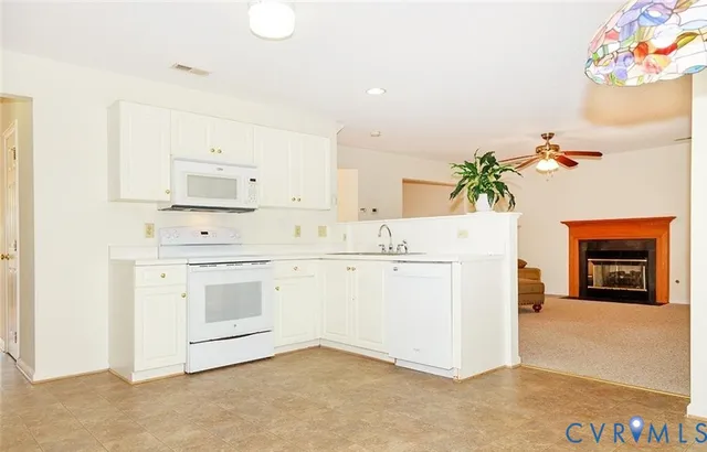 a kitchen with granite countertop white cabinets and white appliances
