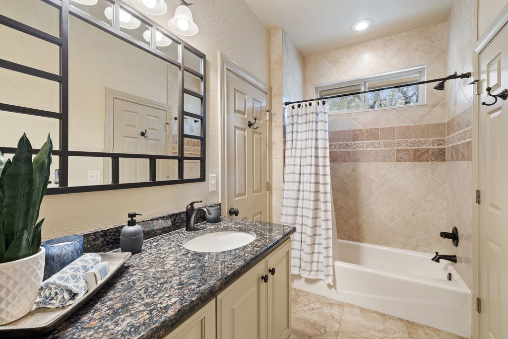 232 Crooked Oak Round Mountain, TX 78663 - Photo 22 of 40 Bathroom with vanity, shower / bath combination with curtain, and a textured wall