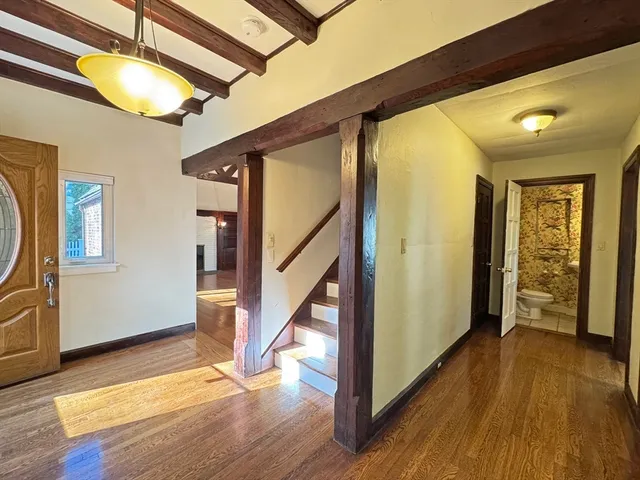 a view of an entryway with wooden floor and door