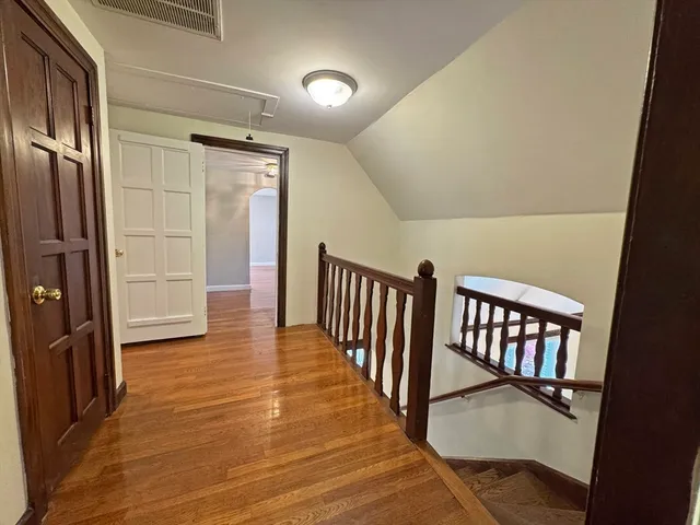 a view of a hallway with entryway wooden floor and windows