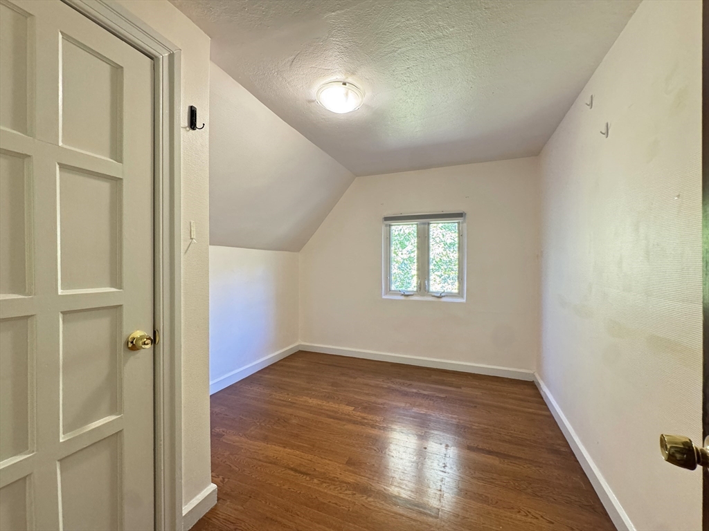 280 Quinobequin Road Newton, MA 02468 - Photo 19 of 31 an empty room with wooden floor and windows