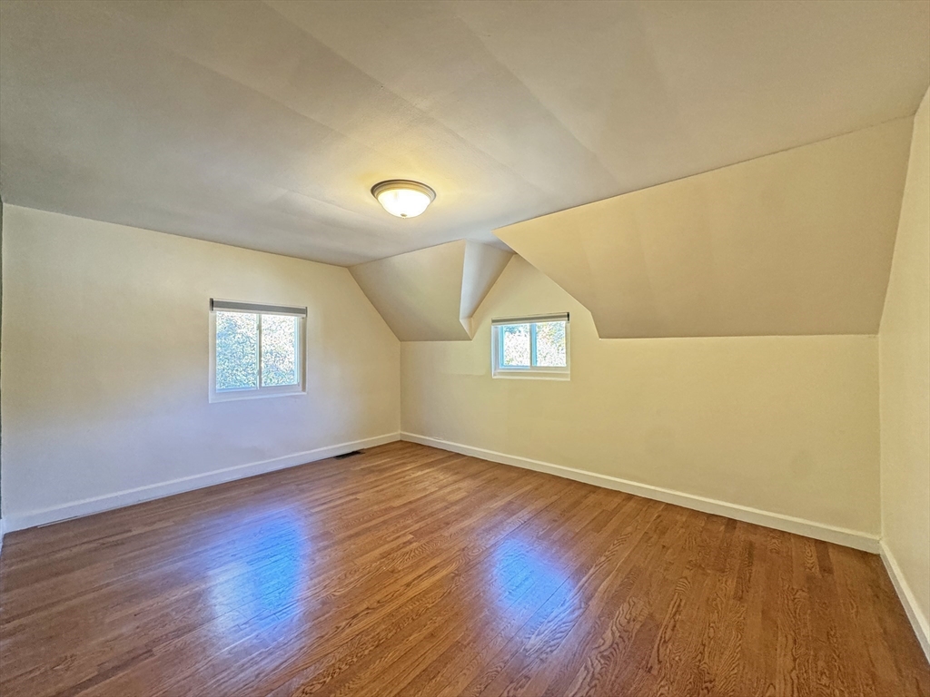 280 Quinobequin Road Newton, MA 02468 - Photo 24 of 31 an empty room with wooden floor and windows