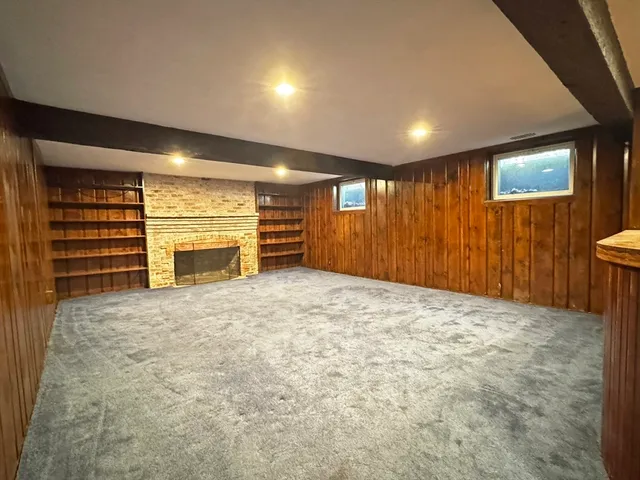 a view of an empty room with a fireplace and a window