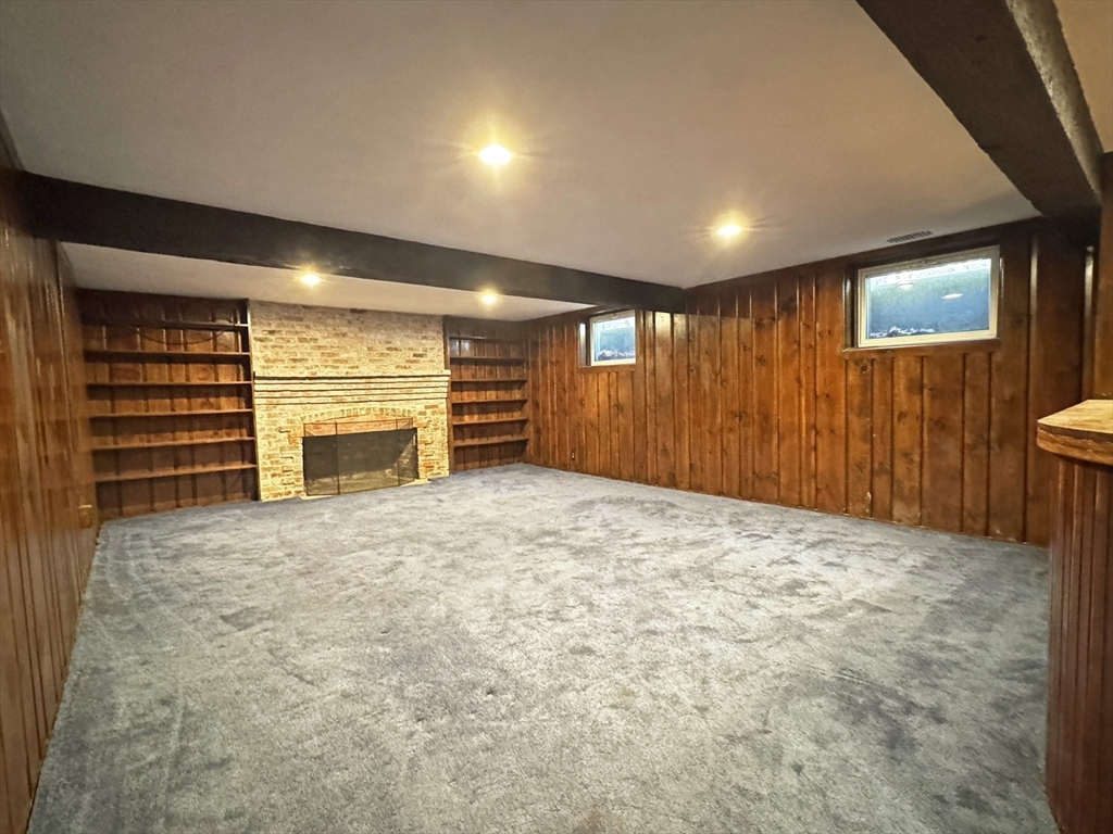 280 Quinobequin Road Newton, MA 02468 - Photo 26 of 31 a view of an empty room with a fireplace and a window