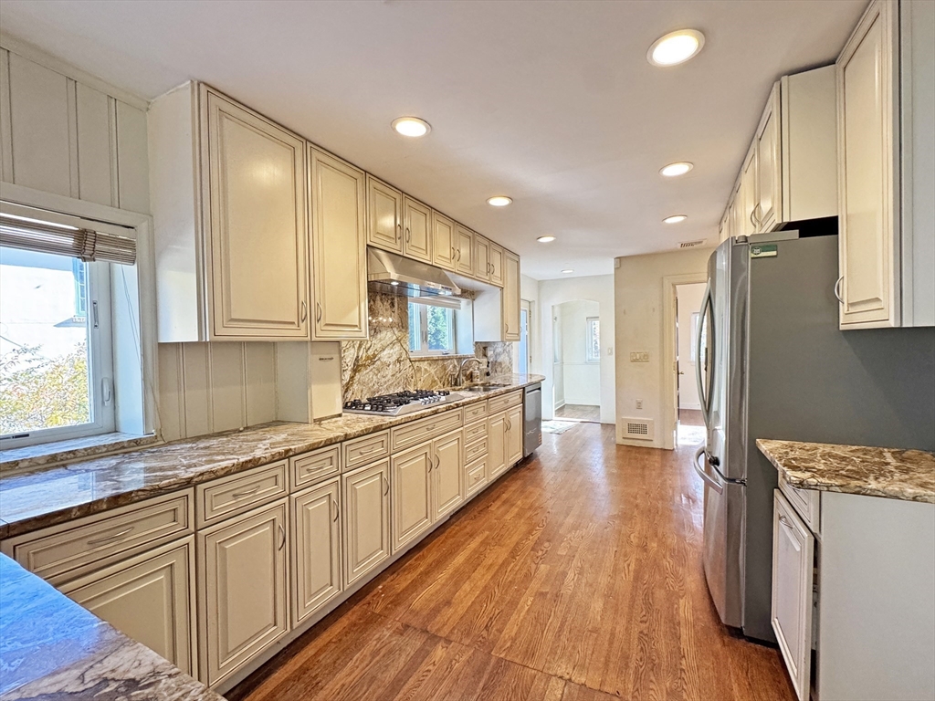 280 Quinobequin Road Newton, MA 02468 - Photo 4 of 31 a large kitchen with stainless steel appliances granite countertop a lot of counter space and wooden floors