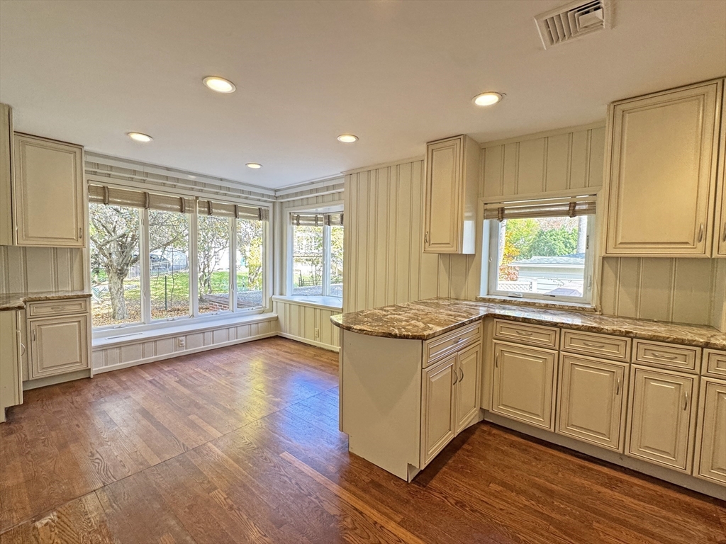 280 Quinobequin Road Newton, MA 02468 - Photo 5 of 31 a kitchen with stainless steel appliances granite countertop a stove a sink and white cabinets with wooden floor next to windows
