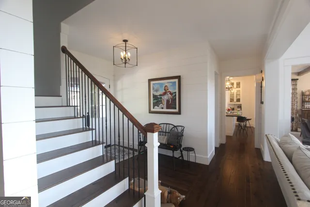 a view of a livingroom with wooden floor and stairs
