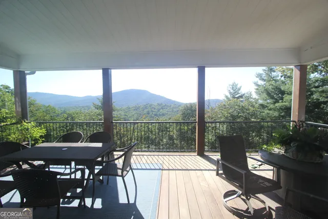 a view of a balcony with chairs and wooden floor