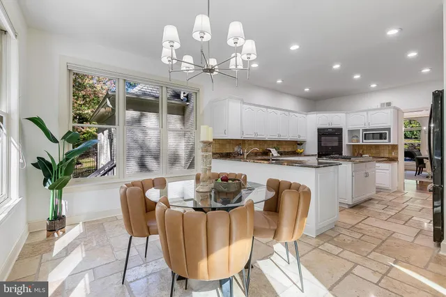 a kitchen with granite countertop a counter space cabinets stainless steel appliances and a chandelier