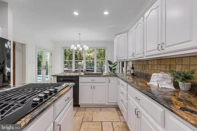 a kitchen with granite countertop white cabinets and white appliances
