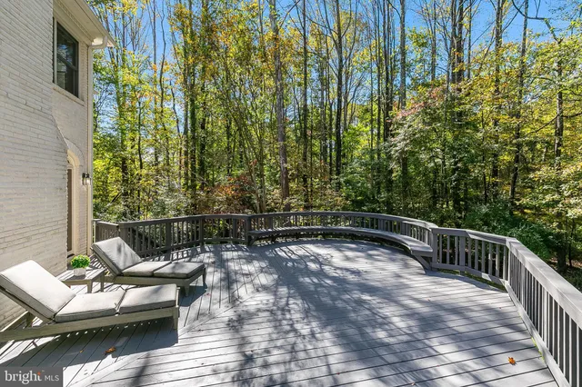a view of a balcony with chairs and wooden fence