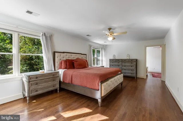 a bedroom with a bed chandelier and a window