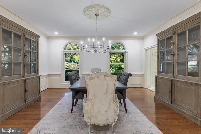 a view of a dining room with furniture a chandelier and wooden floor