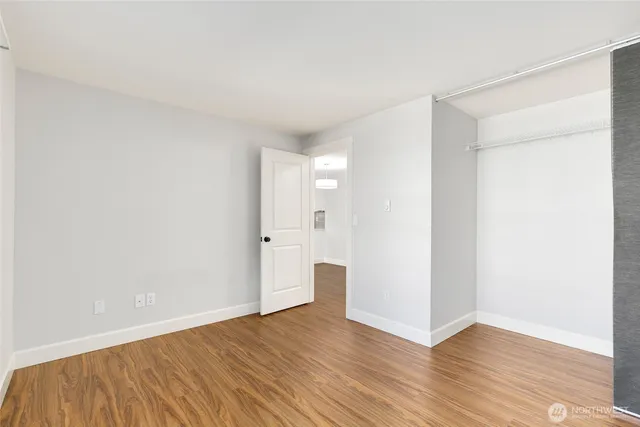 a view of an empty room with wooden floor