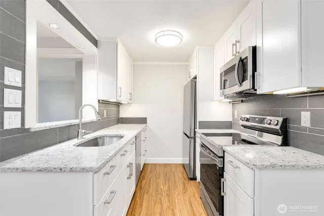 a kitchen with stainless steel appliances granite countertop a sink stove and refrigerator