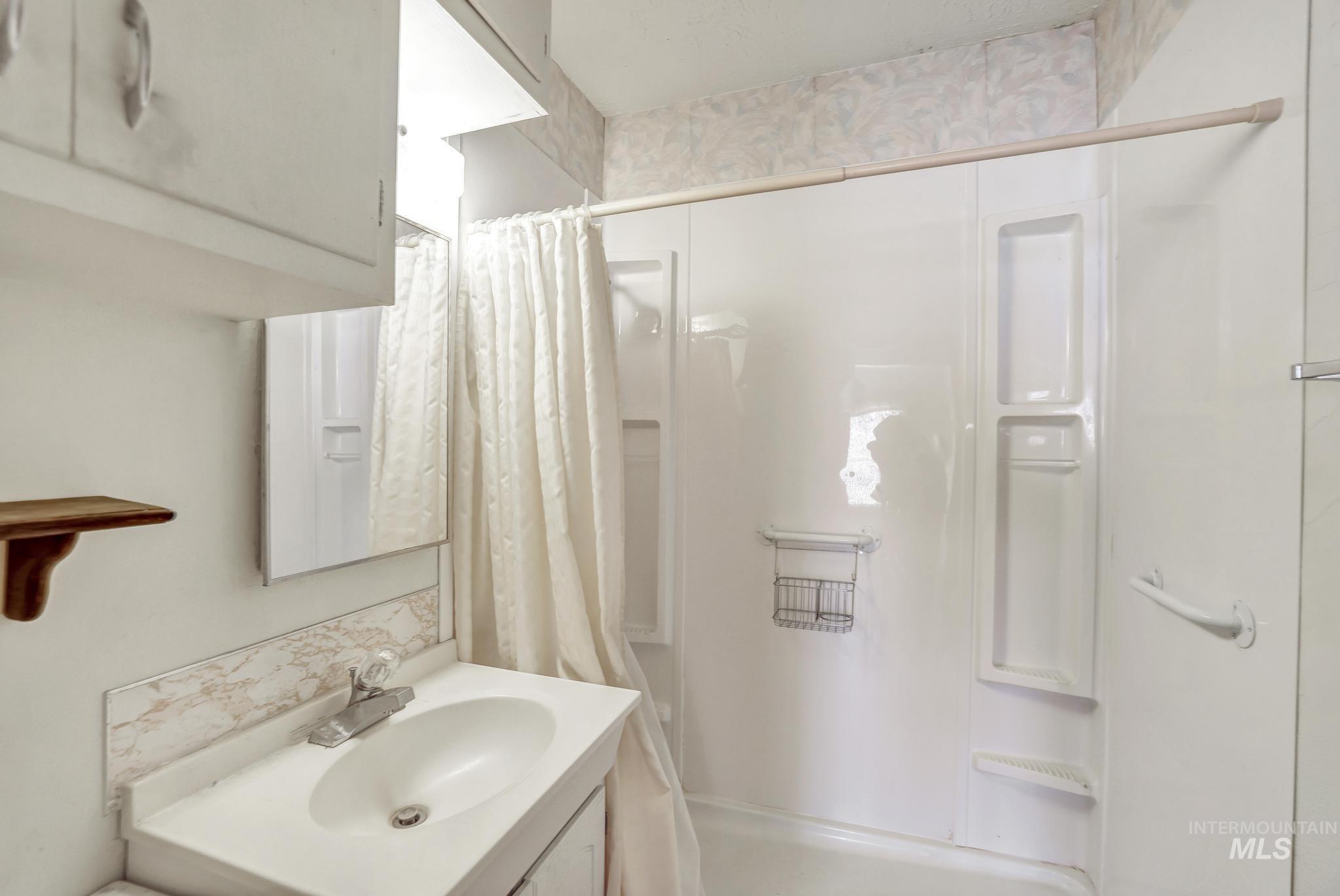 415 Adams Street Twin Falls, ID 83301 - Photo 11 of 20 Bathroom featuring vanity and shower / bathtub combination with curtain