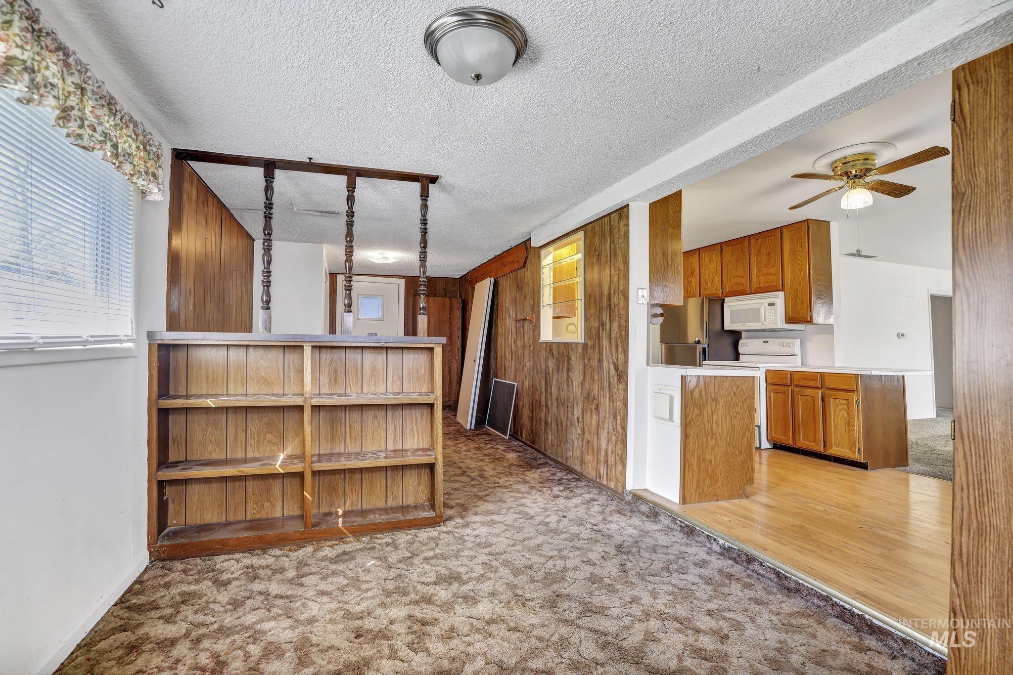 415 Adams Street Twin Falls, ID 83301 - Photo 13 of 20 Kitchen featuring light carpet, light countertops, wood finish cabinetry, white appliances, and ceiling fan