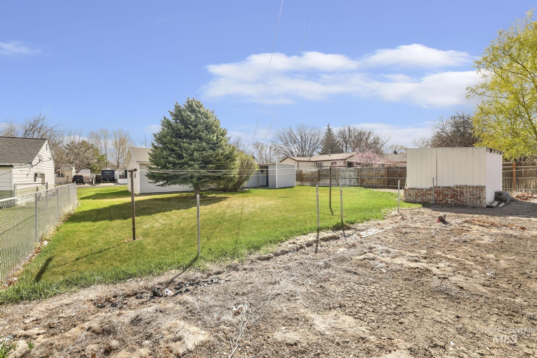 415 Adams Street Twin Falls, ID 83301 - Photo 19 of 20 Fenced backyard featuring a storage unit and a residential view