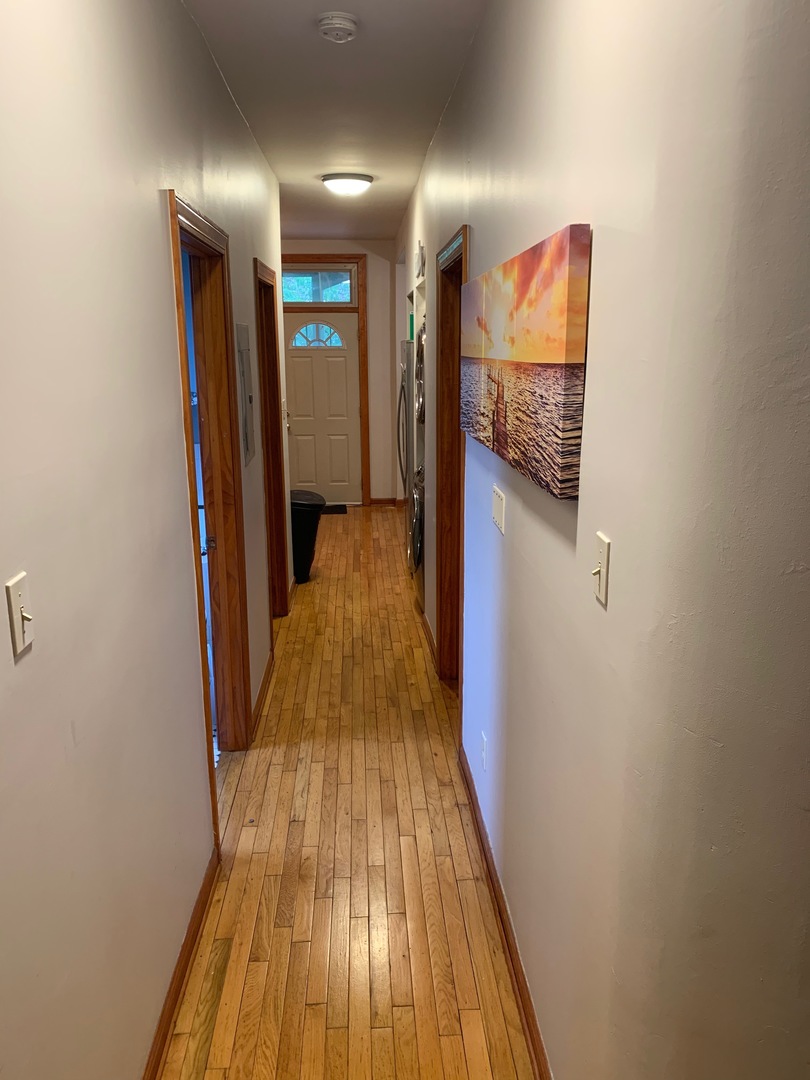 549 East 60th Street, Unit 1 Chicago, IL 60637 - Photo 3 of 11 a view of a hallway with wooden floor and a bathroom