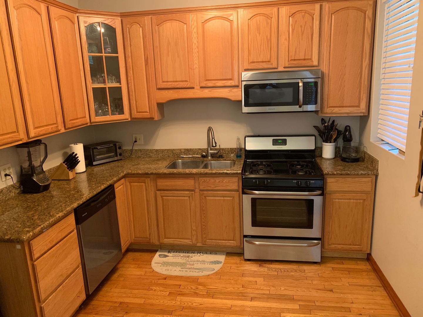 549 East 60th Street, Unit 1 Chicago, IL 60637 - Photo 6 of 11 a kitchen with stainless steel appliances granite countertop a stove a sink and a microwave
