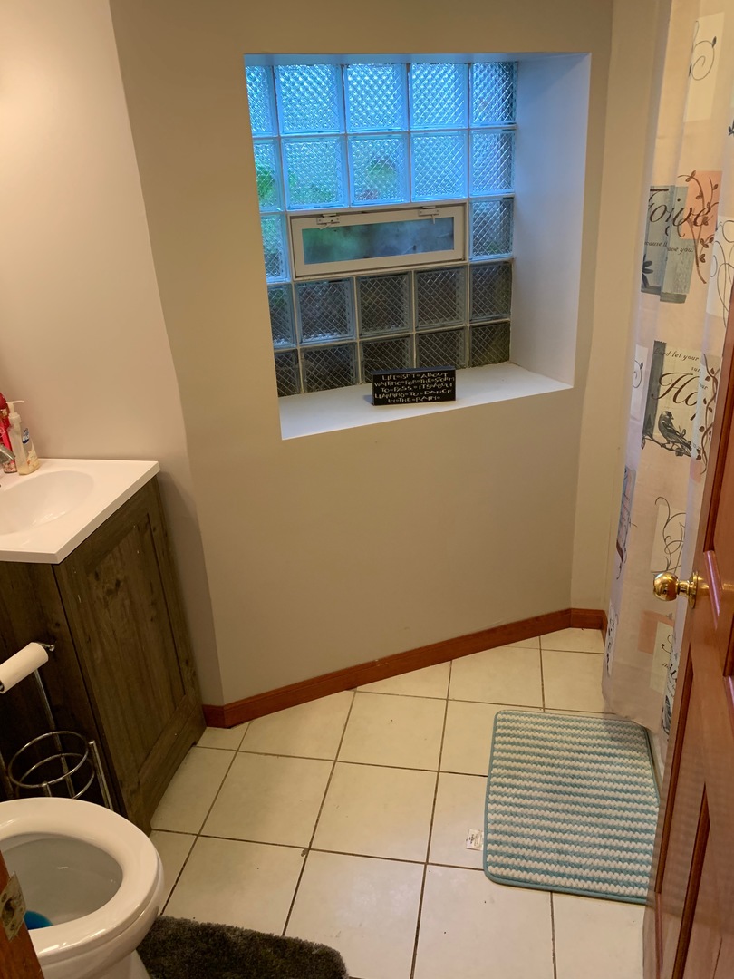 549 East 60th Street, Unit 1 Chicago, IL 60637 - Photo 8 of 11 a bathroom with a sink and a mirror