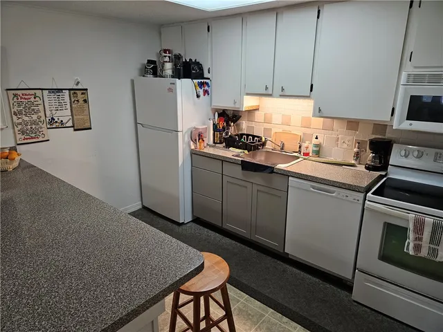 a kitchen with a sink a refrigerator and cabinets