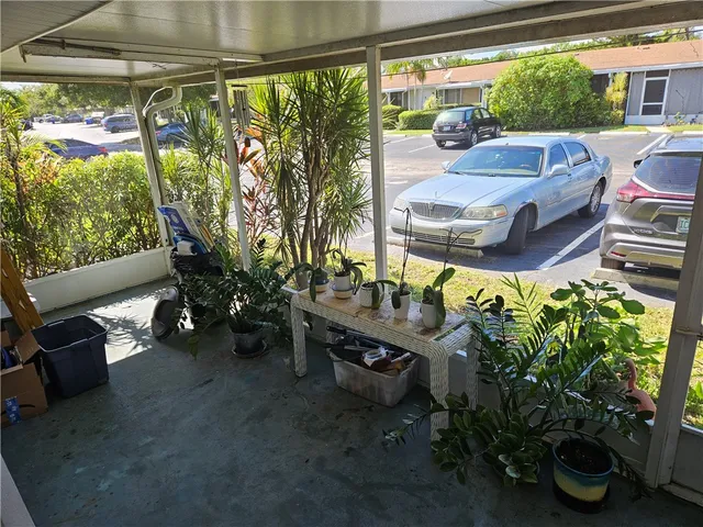 a view of a porch with furniture and a garden