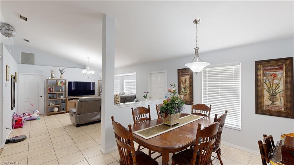 2801 46th Street Southwest Naples, FL 34116 - Photo 8 of 50 Tiled dining space with a chandelier and vaulted ceiling