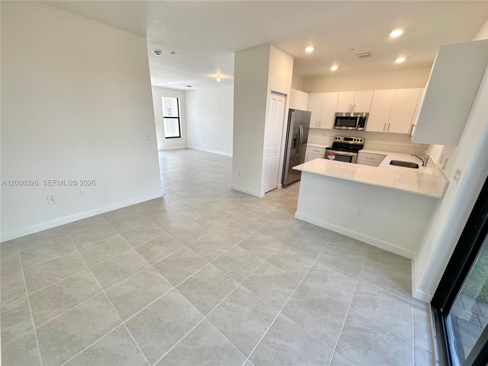 261 Southwest 159th Way Pembroke Pines, FL 33027 - Photo 3 of 17 a view of kitchen with stainless steel appliances a refrigerator counter top space and cabinets