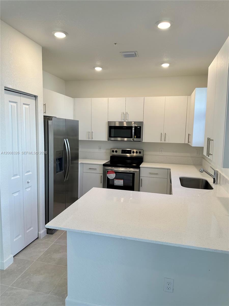 261 Southwest 159th Way Pembroke Pines, FL 33027 - Photo 4 of 17 a large kitchen with stainless steel appliances a refrigerator and a sink