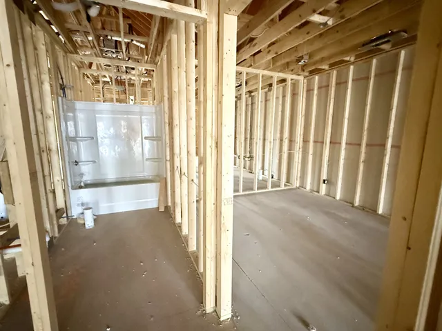 a view of a hallway with wooden floor and door