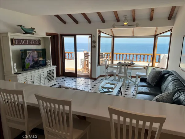 a living room with furniture a flat screen tv and a floor to ceiling window