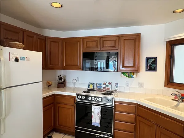 a kitchen with a sink a refrigerator and a stove top oven