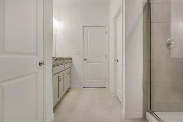 a view of a hallway with white cabinets