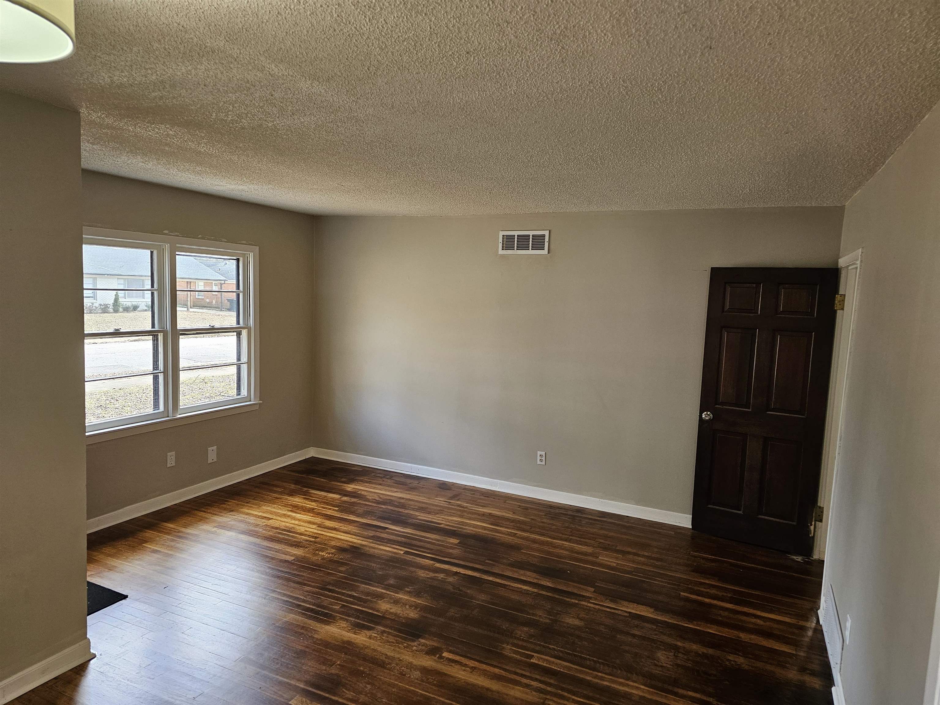 1485 Ivy Road Memphis, TN 38117 - Photo 8 of 22 a view of an empty room with wooden floor and a window