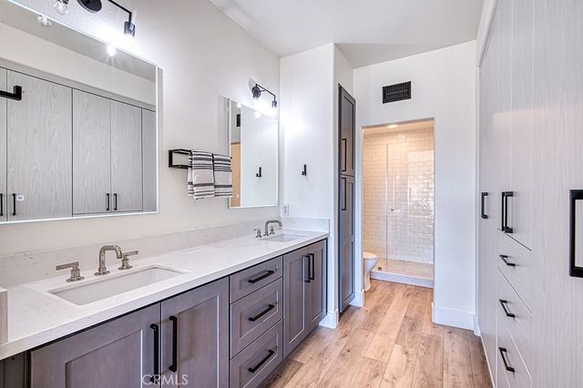 a spacious bathroom with a double vanity sink a mirror and a shower