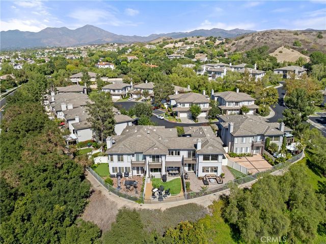 an aerial view of residential houses with outdoor space and trees