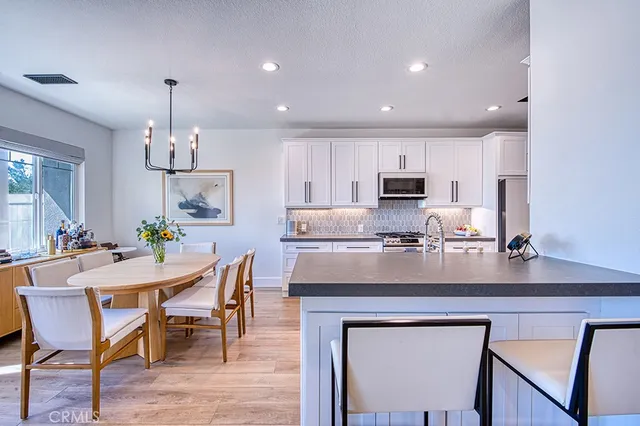 a kitchen with kitchen island granite countertop a center island a sink stainless steel appliances and cabinets