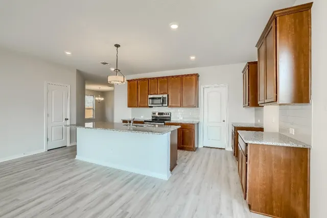 a kitchen with stainless steel appliances granite countertop a sink stove and refrigerator