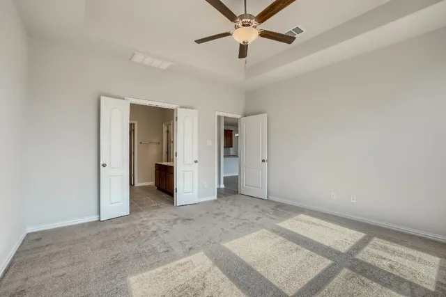 an empty room with closet and a ceiling fan