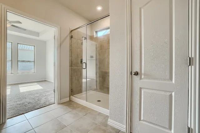 a bathroom with a shower and a glass door