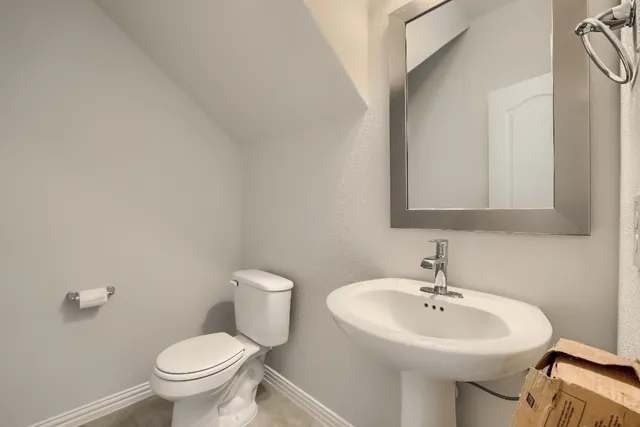 a bathroom with a sink toilet and a mirror