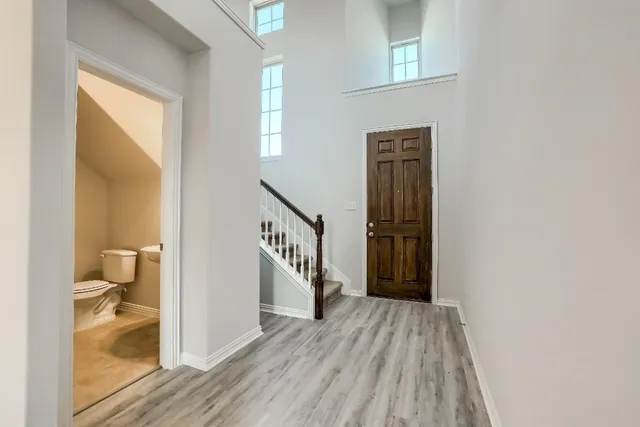a view of a hallway with wooden floor and staircase