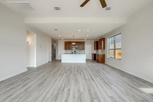 a view of empty room with wooden floor and window