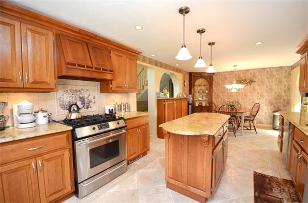 150 Dunstable Road Chelmsford, MA 01863 - Photo 3 of 30 a kitchen with stainless steel appliances granite countertop a stove a sink dishwasher and a refrigerator with wooden cabinets