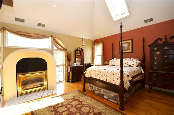 150 Dunstable Road Chelmsford, MA 01863 - Photo 10 of 30 a bed room with a bed and a fireplace