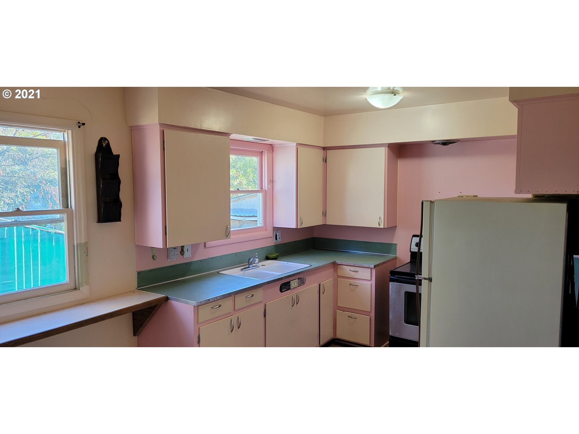 421 Smith Street Riddle, OR 97469 - Photo 10 of 14 a kitchen with stainless steel appliances granite countertop a sink and a refrigerator