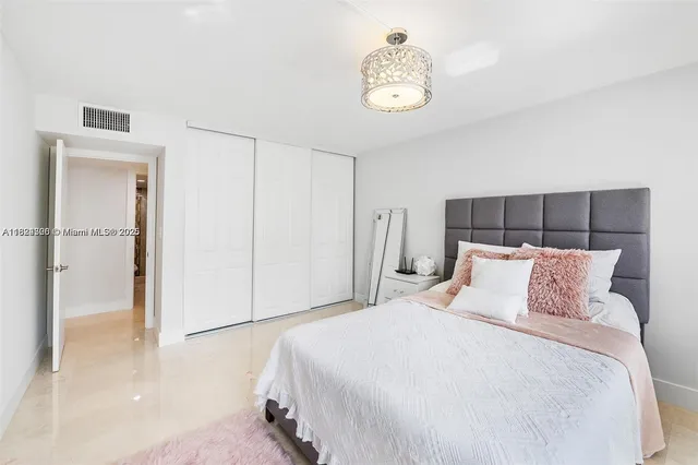 a bedroom with a bed and a chandelier