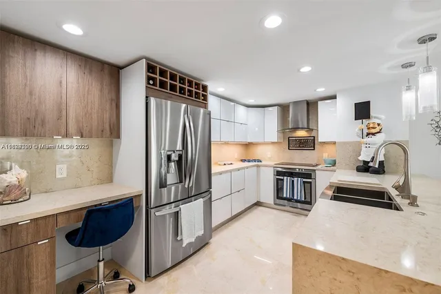 a kitchen with stainless steel appliances granite countertop a refrigerator and a stove top oven