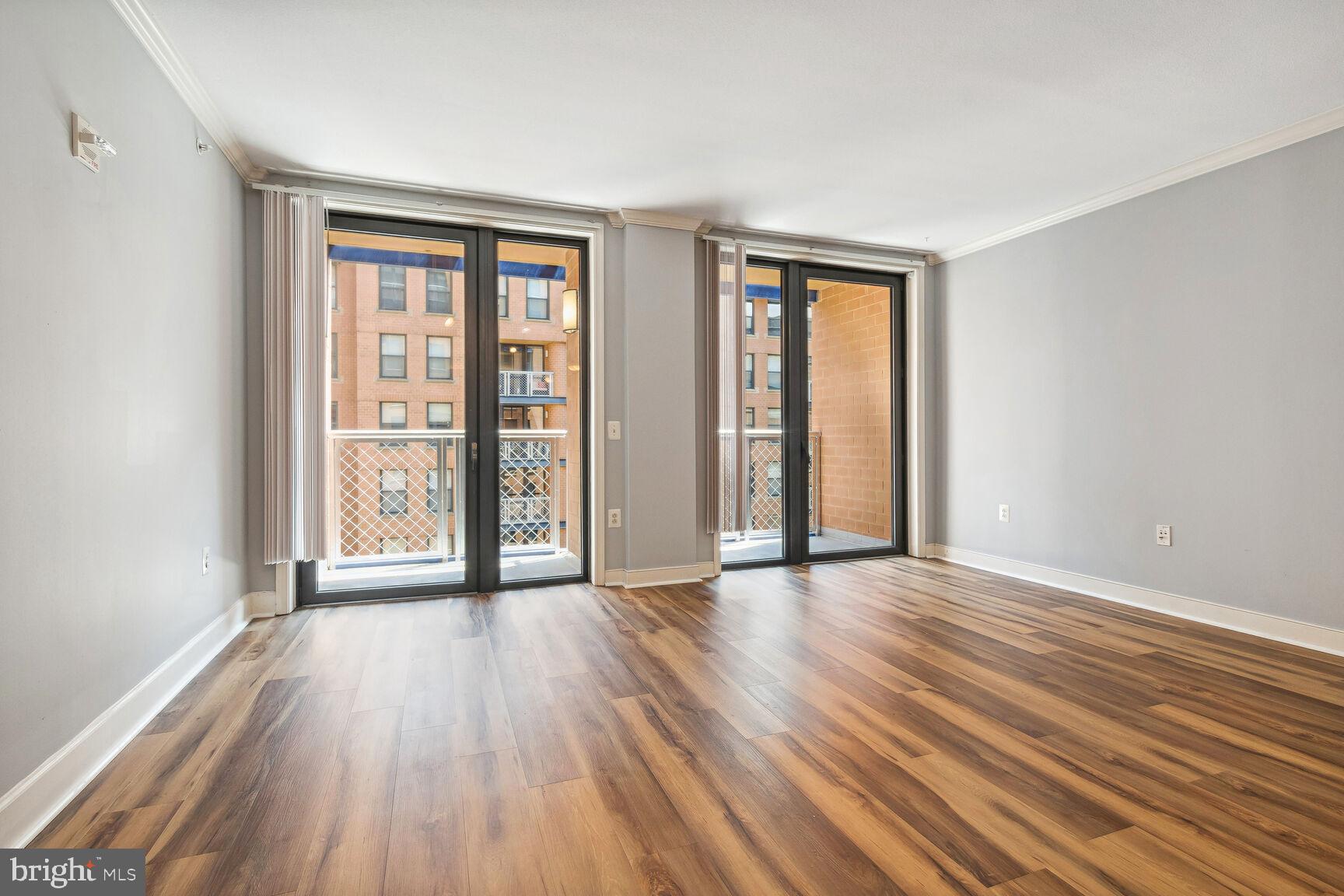 616 E Street Northwest, Unit 807 Washington, DC 20004 - Photo 2 of 24 an empty room with wooden floor and windows